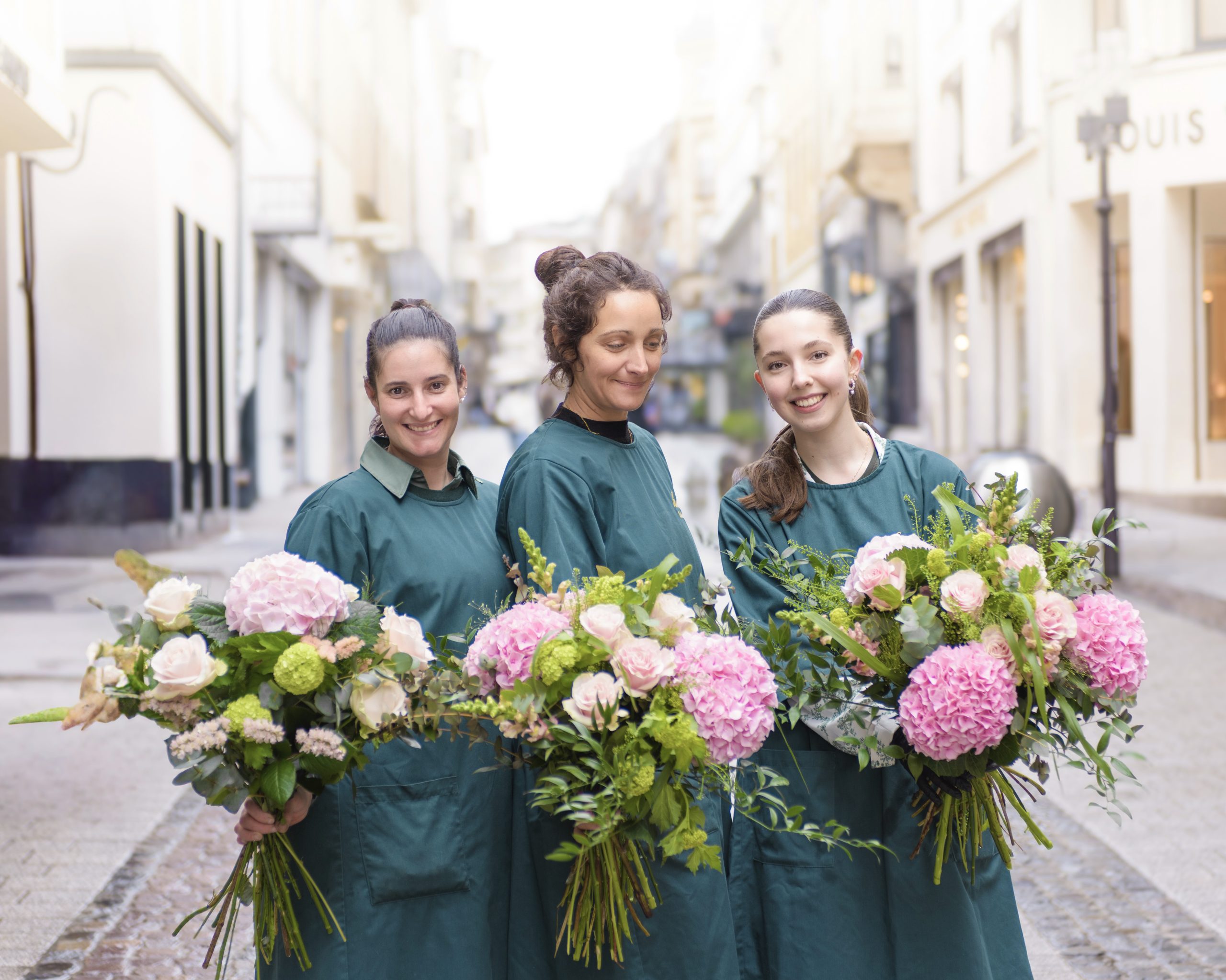 Portait des fleuristes de Fleurs Hortos Luxembourg tenant des bouquets colorés printaniers